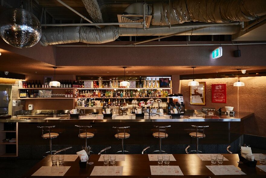 Interior of Belles, with tables in foreground, shiny bar at back. 