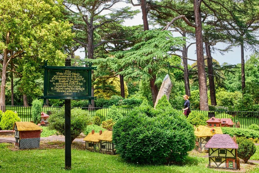 A miniature Tudor village in a garden.