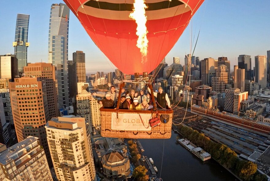 A hot air balloon flight over the Melbourne city skyline during sunrise.