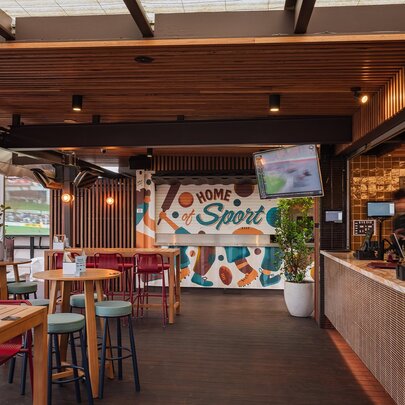 A rooftop bar with a tv and mural.