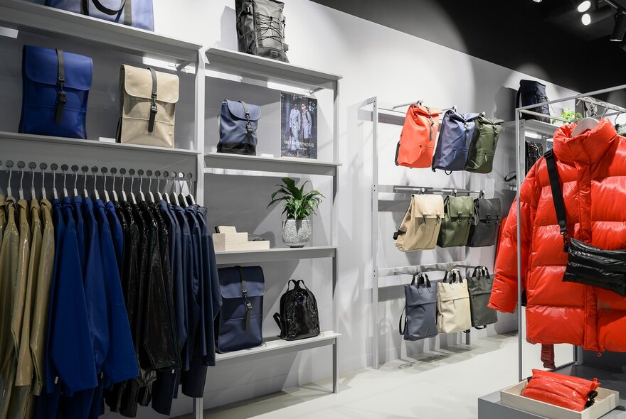 Inside a store with backpacks and jackets on the shelves and hangers.