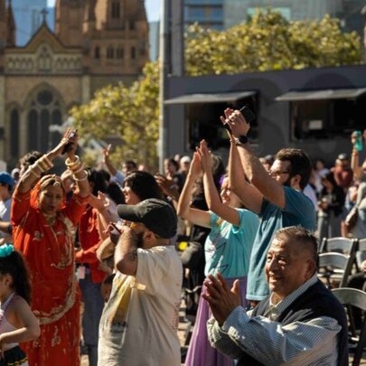 A crowd clapping and celebrating as they watch a performance.