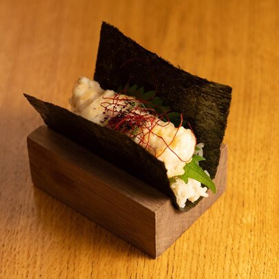 Fish and rice in a piece of seaweed, in a timber stand. 