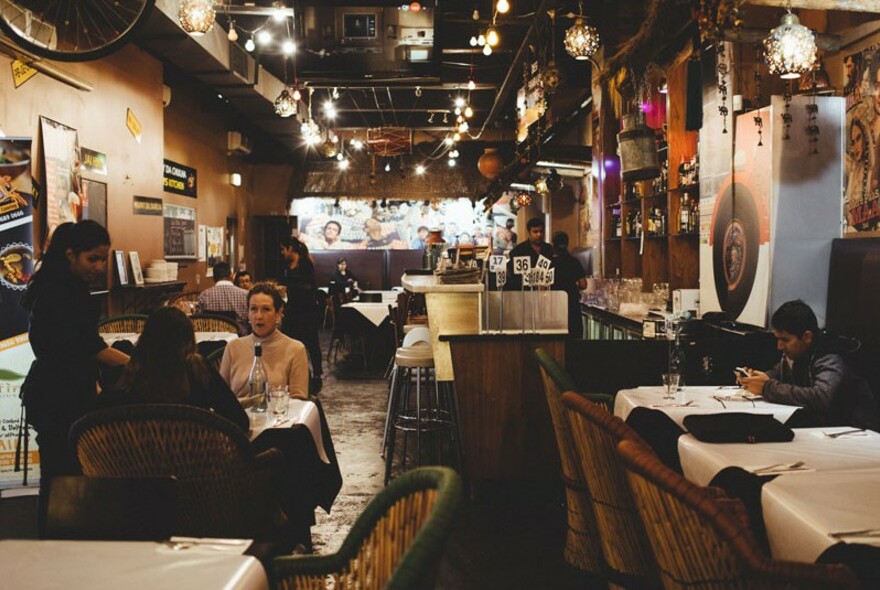 The interior of Desi Dhaba showing two diners being attended to by a waitress.