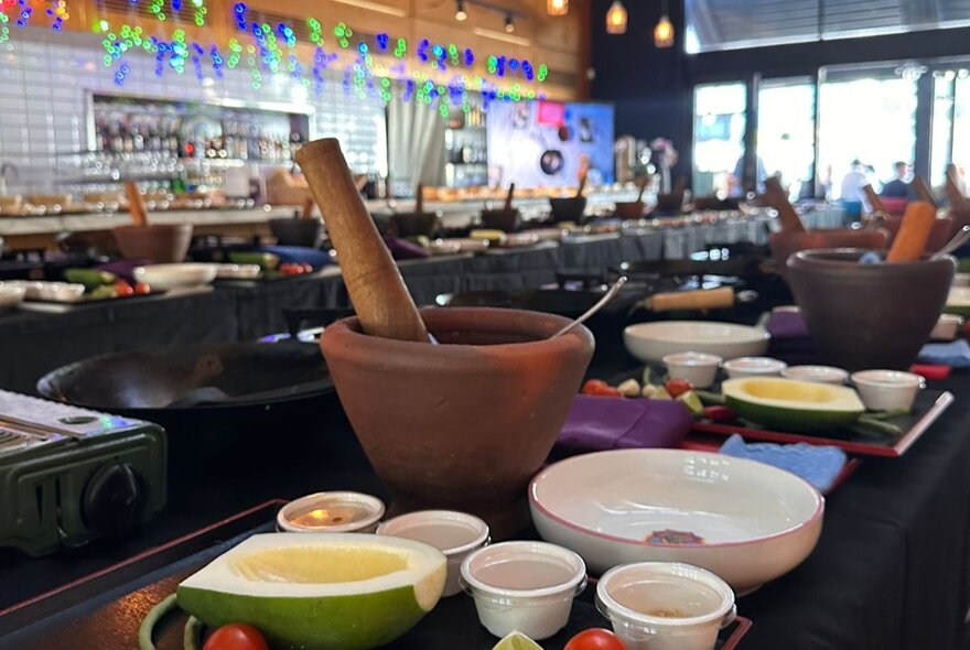Bowls and sauce-making tools on a bench in a restaurant setting.