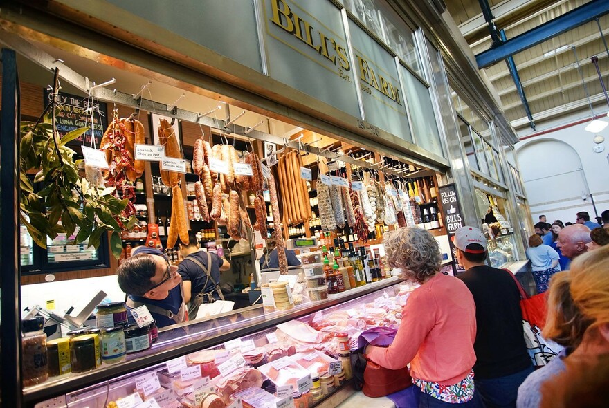 Angled view of the exterior of Bill's Farm with man serving customers. 