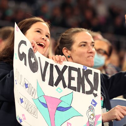 Netball fans holding posters in the stands.