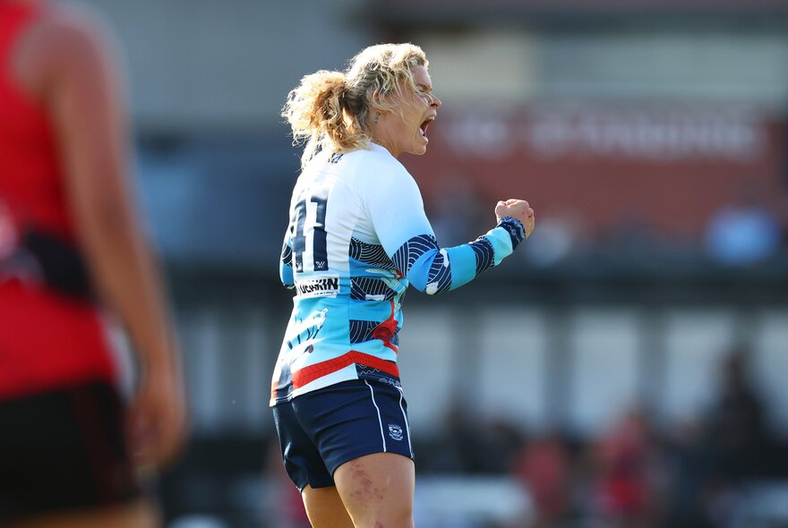 A Geelong Cats ALFW player celebrating with a fist pump during a game.