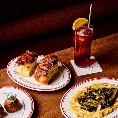 Vegan savoury dishes with a tall drink with straw and orange slice.