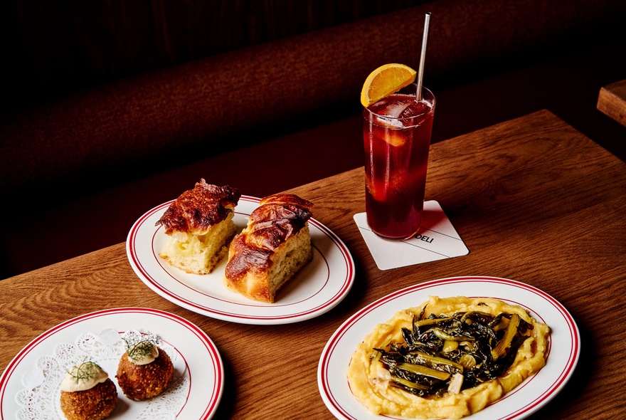 Vegan savoury dishes with a tall drink with straw and orange slice.