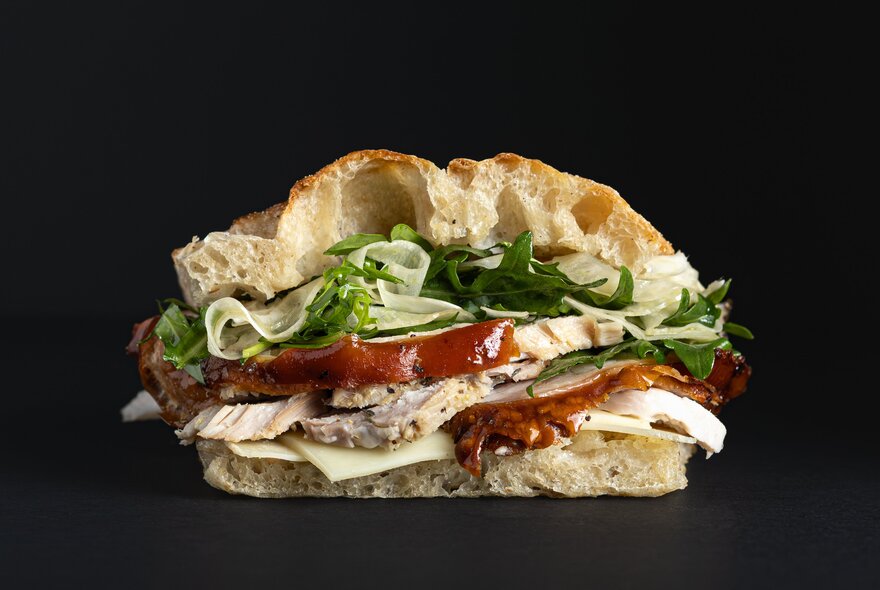 Porchetta panino from Saluministi, featuring slow-roasted pork and rocket salad on ciabatta.