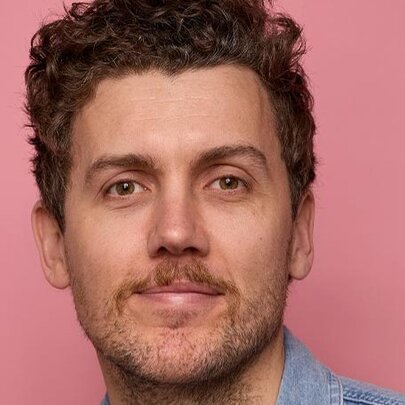 Comedian with light goatee and dark hair.