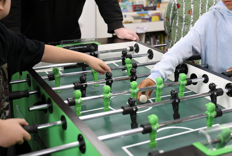 Small hands playing foosball.