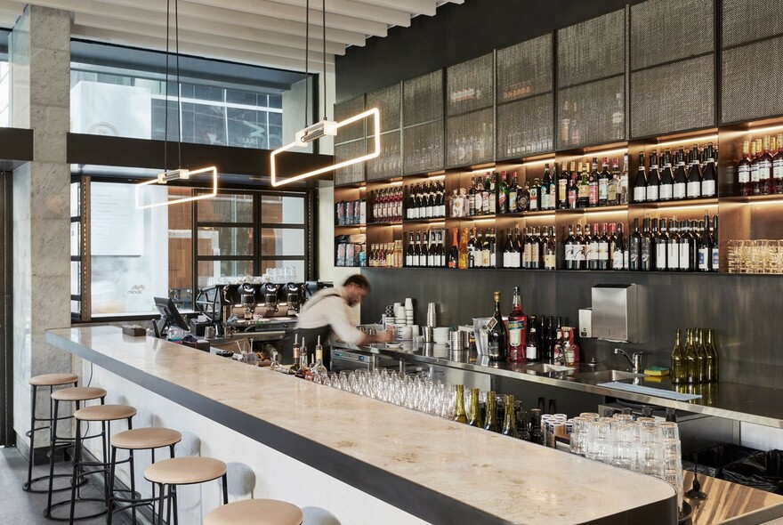 Bar setting with wine bottles and bar stools.