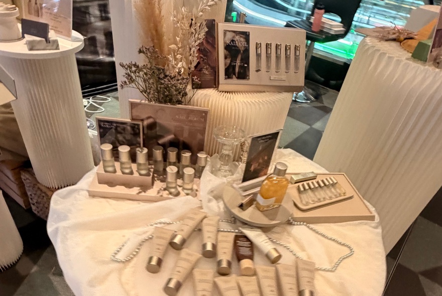 Table of beauty products, tubes and vials on display.