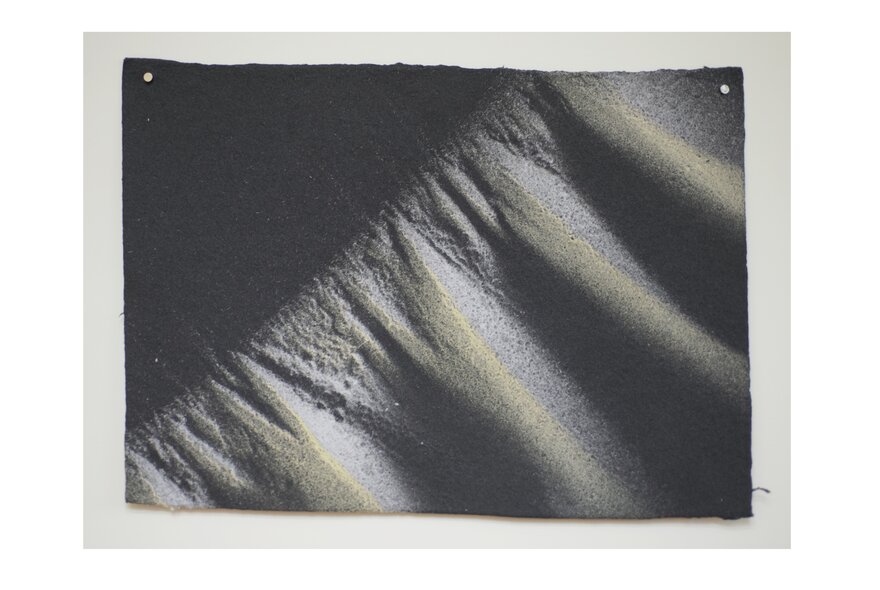 Textural photographic artwork in shades of grey.