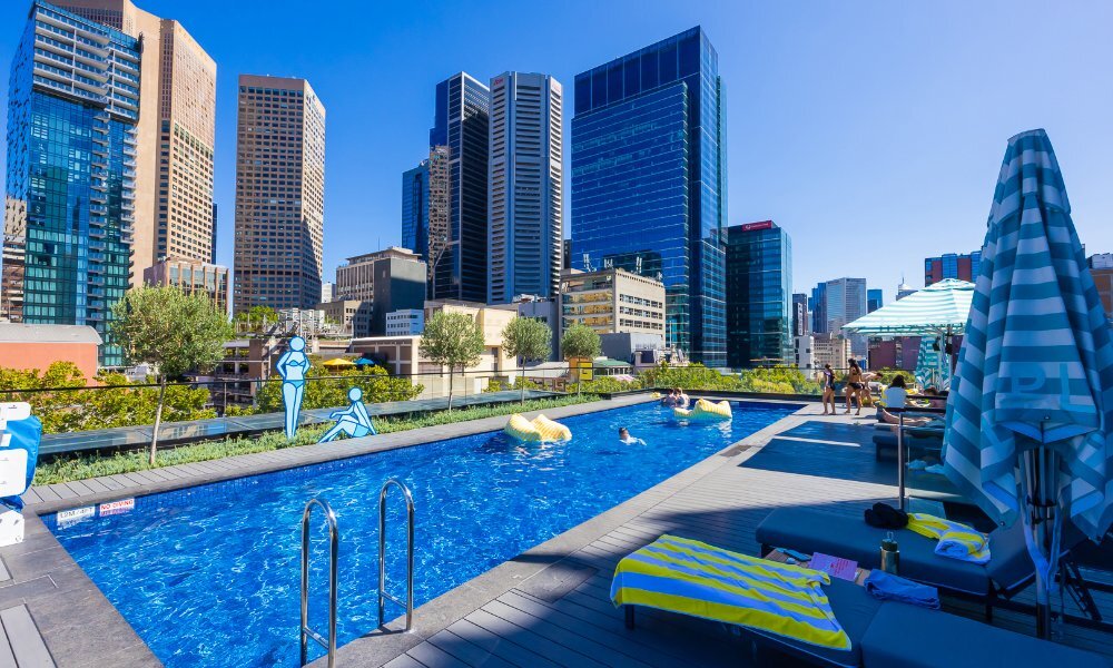 Hotel rooftop pool with city skyline views.