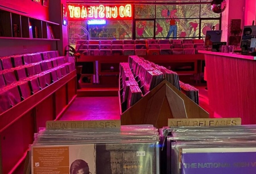 A record store lit up by a red and blue neon sign