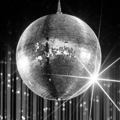 Silver glitter ball in front of shiny streamers.