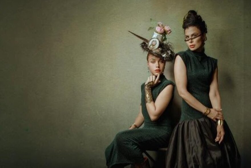 Models against green/sage background wearing formal gowns and headgear.