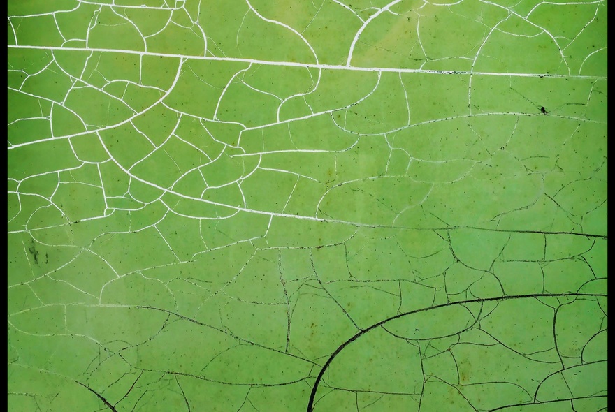 A large green artwork with lines appearing like silver cracks over the work.