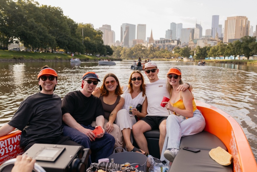 A group of people posing for a photo on a small boat on the Yarra River in Melbourne.