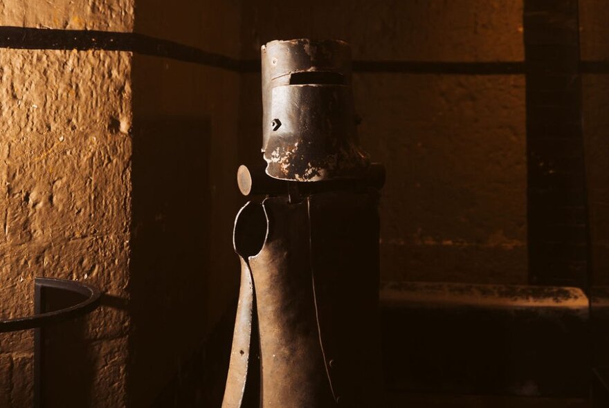 Ned Kelly's armour, displayed in a dimly lit corner of a stone room at the Old Melbourne Gaol.