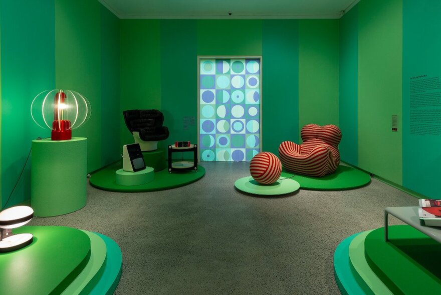 A modern designed green room with funky chairs and artworks. 