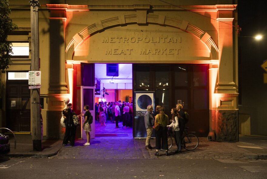 Venue with purple lights within, with lamplit doorway at night.