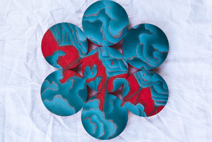 A flower-shaped red and teal art piece. 