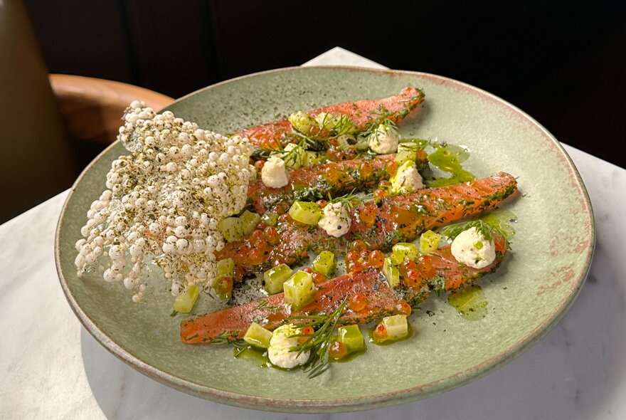 Looking down at a restaurant dish with puffed rice garnish. 