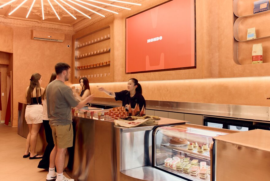 Customers ordering gelato at the counter of a modern shop, Mondo Gelateria in Melbourne.