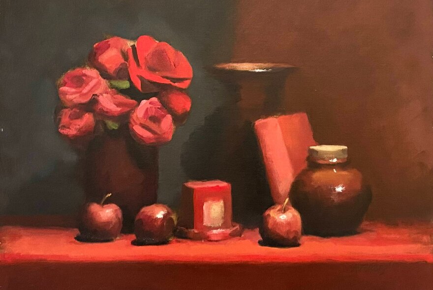 Oil painting of a still life featuring red flowers in a dark vase, paired with ceramic jars, a red book, and scattered red apples on a red tabletop.