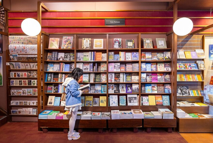 A girl is looking at books in a bookshop