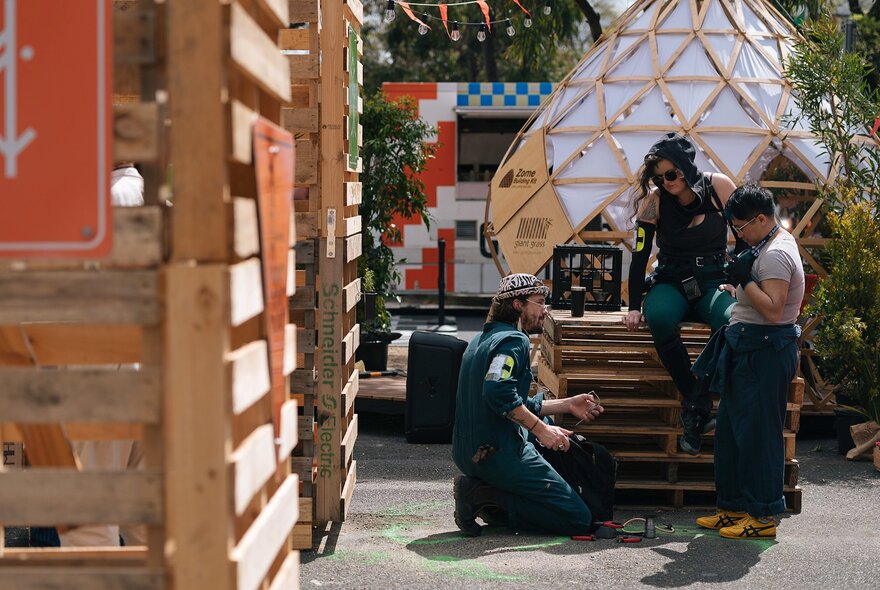 Game participants looking at a structure near packing case fences.