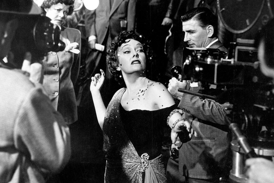 Gloria Swanson in an off-the-shoulder gown looking dramatically at the camera in Sunset Boulevard.