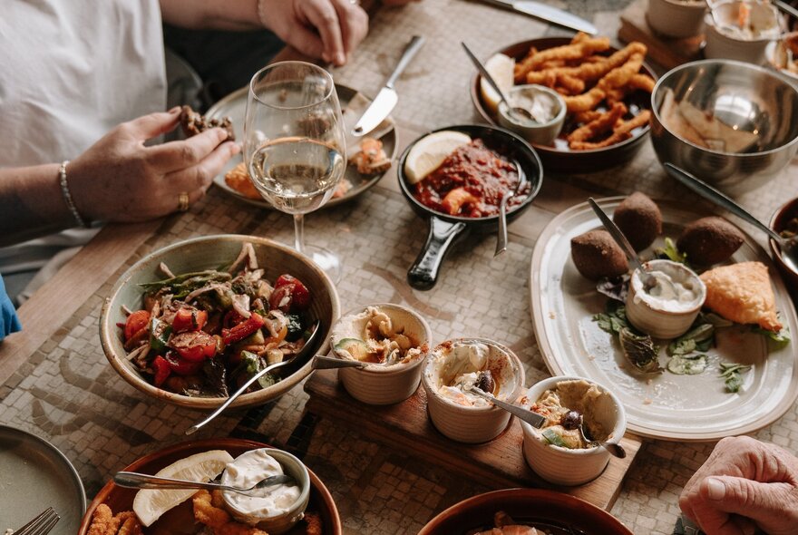 Looking down at plates of Lebanese food arranged on a table in a restaurant.