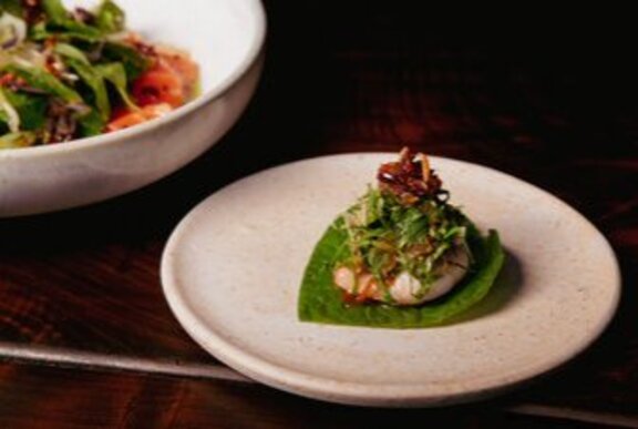 Betel-leaf plating of Asian starter with green garnish.