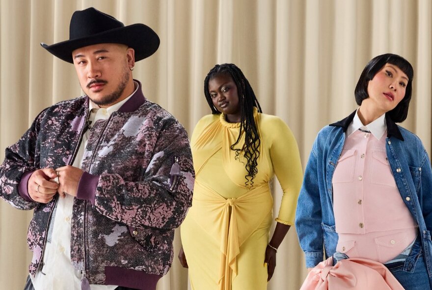 Male model wearing a cowboy hat with two pregnant models in the background.