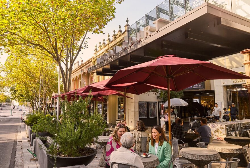 A group of women are having cake at an outdoor cafe.