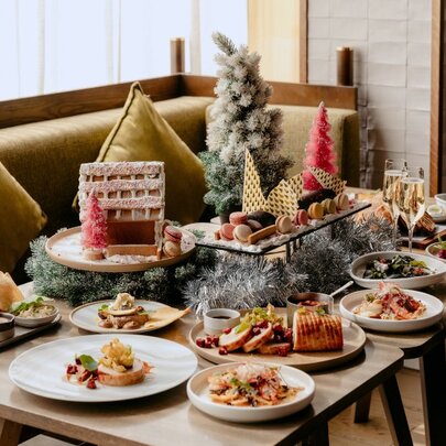 A festive dining setup featuring a Christmas dining experience on a table, with banquette seating.