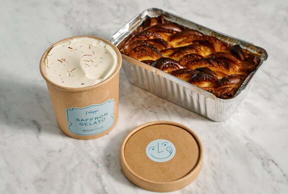 A pudding in silver takeaway tray and a tub of ice cream.