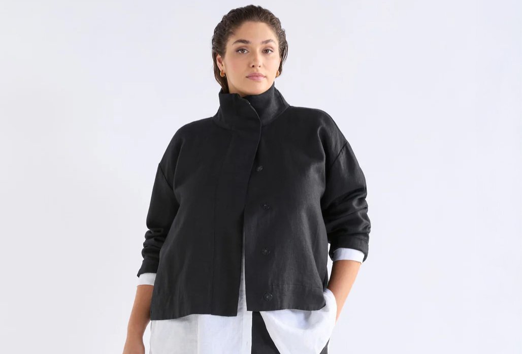 A model wearing a black cropped funnel neck jacket.