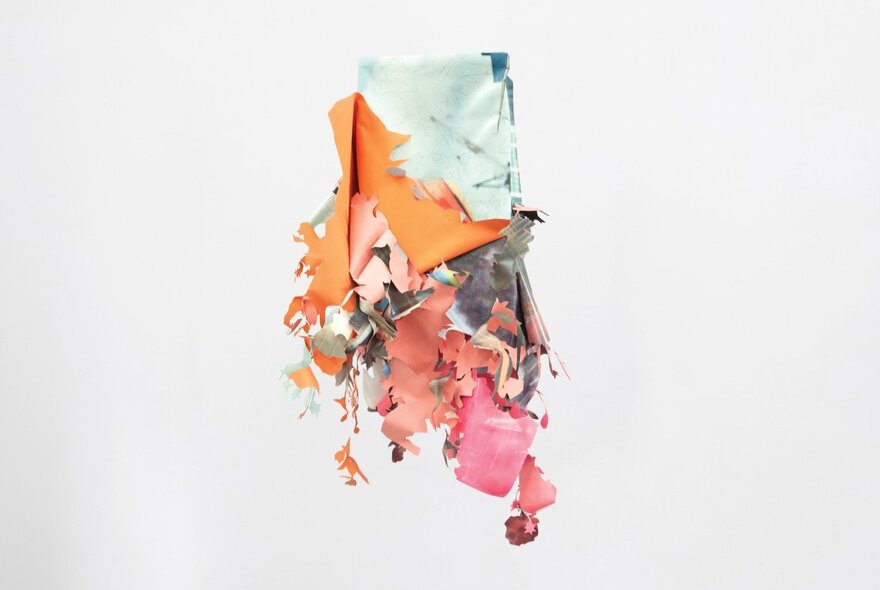 A sculptural piece hanging on a white gallery wall, made from vinyl, acrylic paint, graphite, and tape.