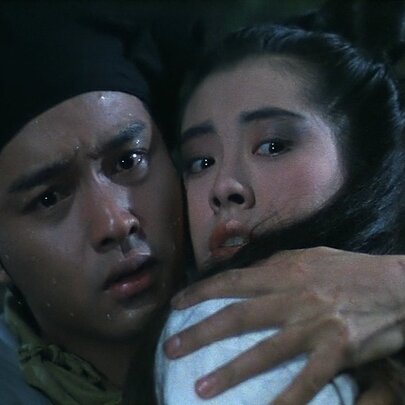 A scene from the 1987 Hong Kong film A Chinese Ghost Story showing a man and woman with their heads close together, looking worried.