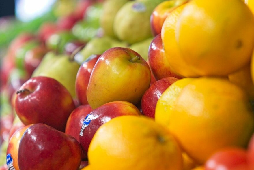 A tight shot of apples and oranges in a fruit store. 