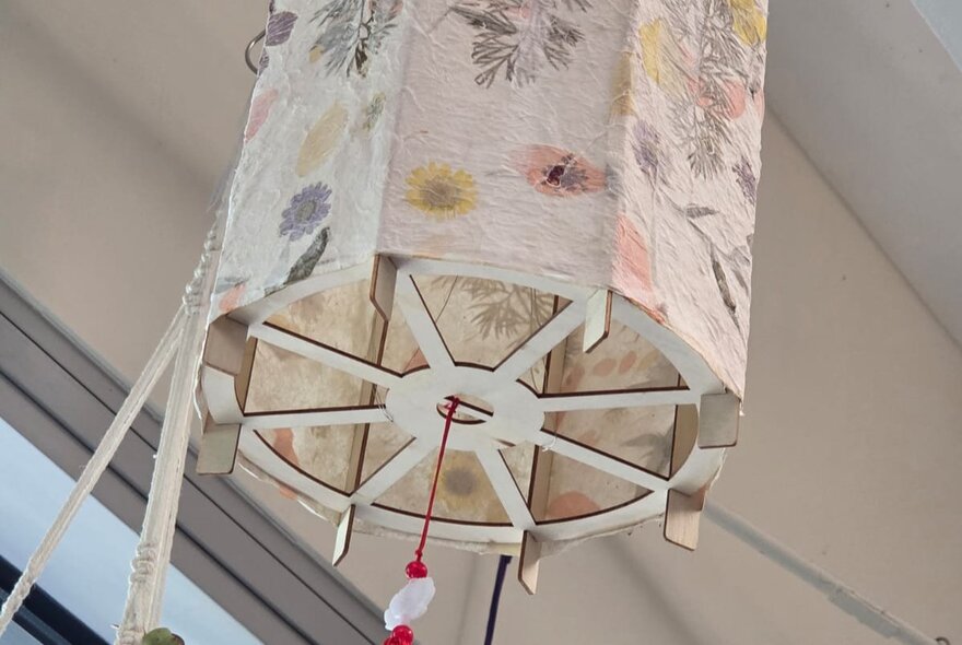 A decorated lampshade featuring homemade paper and pressed flowers. 