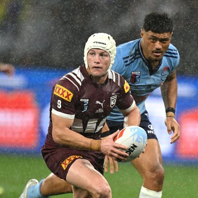 Two NRL State of Origin players on the field in the rain, playing rugby.