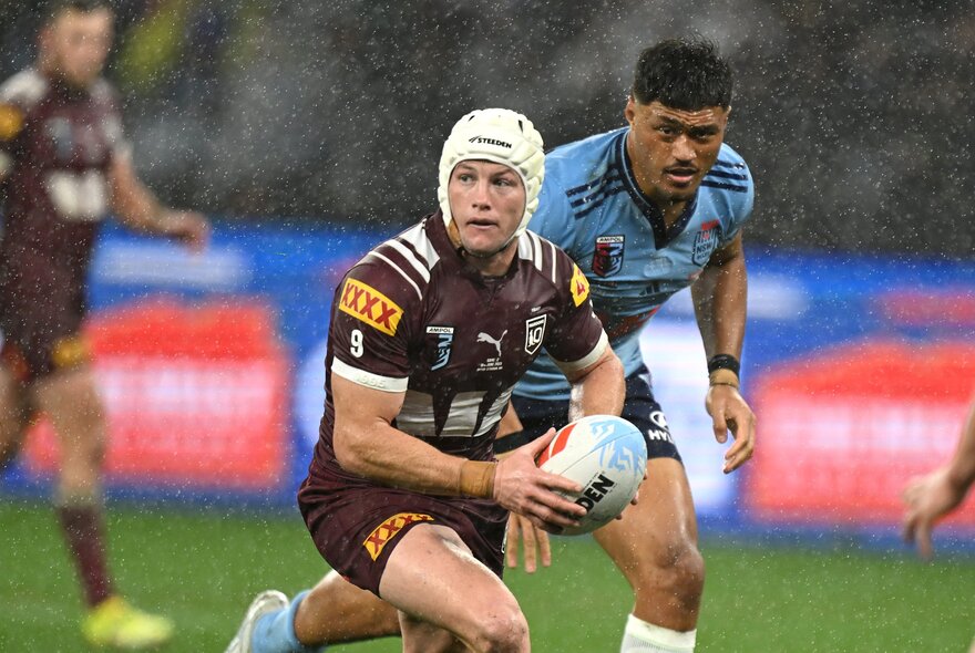 Two NRL State of Origin players on the field in the rain, playing rugby.