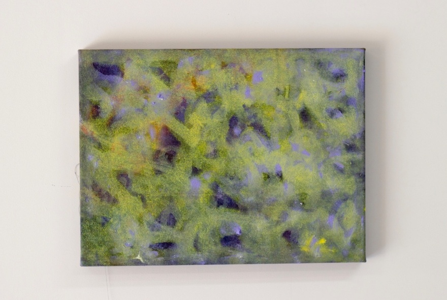 An abstract artwork of pale yellow, green and blue colours and splotches hanging  on a gallery wall.
